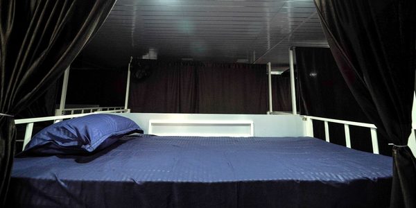 Bunk bed with full privacy curtain and reading light in the air-conditioned dormitory at Zest Stays 1054