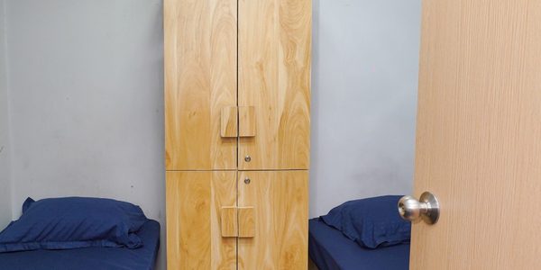Double sharing room with two beds, wall-mounted air conditioning and a full-height wardrobe at Zest Stays 1054
