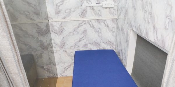 Fully enclosed private partition with marble-tiled walls, a curtain and its own power socket at Zest Stays 1054